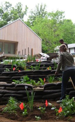 A group works in the terraced garden adjacent to the house.