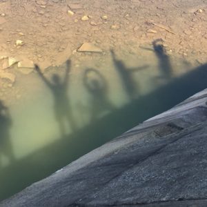A group of students silhouettes in the water.