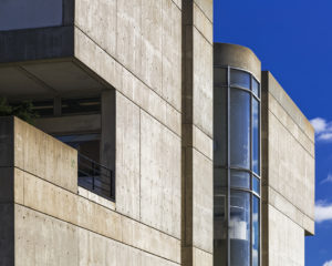 A cropped photo of the Art + Architecture Building, showing the top corner of the building against a blue sky.