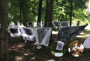 Student headstone rubbings displayed among trees