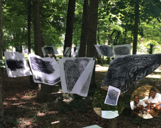 Student headstone rubbings displayed among trees