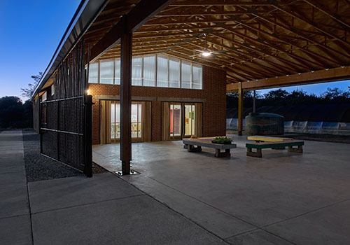 The open patio area of the building leading to the entry at night.