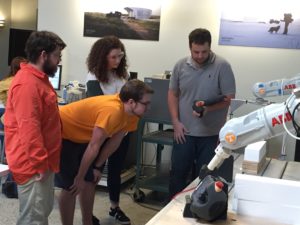 students working with robot arm