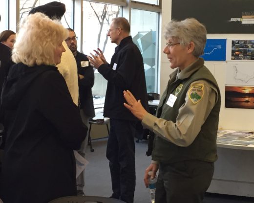 Two women, one in a national park uniform, talking at a gathering for the project.