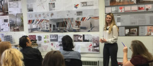 A female student presents her work to an audience