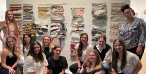 students and professor with weavings