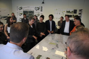 Faculty and students looking at a large map on table