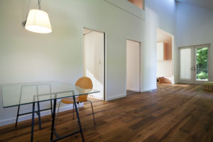 An interior photo of the New Norris House showing a wooden floor and the "marriage wall"