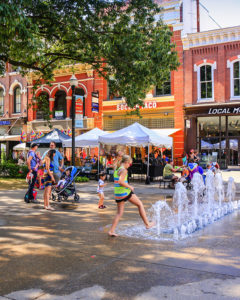 A young girl plays in a fountain in Market Square in Knoxville, TN