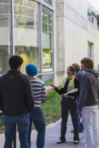 A group stands on the sidewalk outside of the Art + Architecture building.