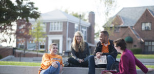 Male and female students sitting on concrete steps outside Fred D. Brown Jr residence hall across from Melrose Avenue with Christian Student Center building in background. Photo by Jennie Andrews. Found in CreativeMini/SharedPhotos/Jennie Andrews 2014/FredBrown.