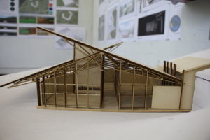 An architectural model of a house with an angular roof.