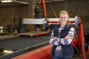 girl standing in front of a waterjet cutter