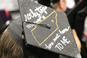 The top of a mortarboard at commencement reading, "Rocky Top you'll always be home sweet home to me"