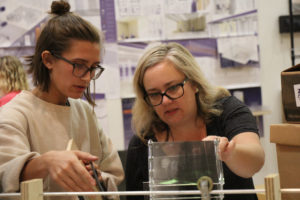 A faculty member talks with a student about her project.