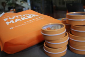 A close-up view of an orange bag and tins of candy at an Open House event.
