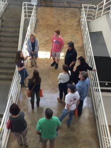 Prospective students and their families stand on a walkway in the Art + Architecture Building during a tour.