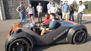 Two students in an open-topped experimental car.