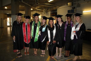Students smiling in caps and gowns