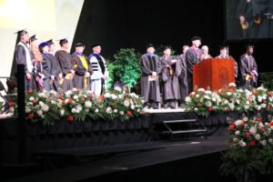 Stage party standing at Spring Commencement 2018