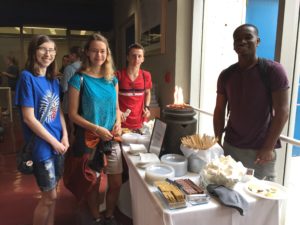 Students smiling around the s'mores bar