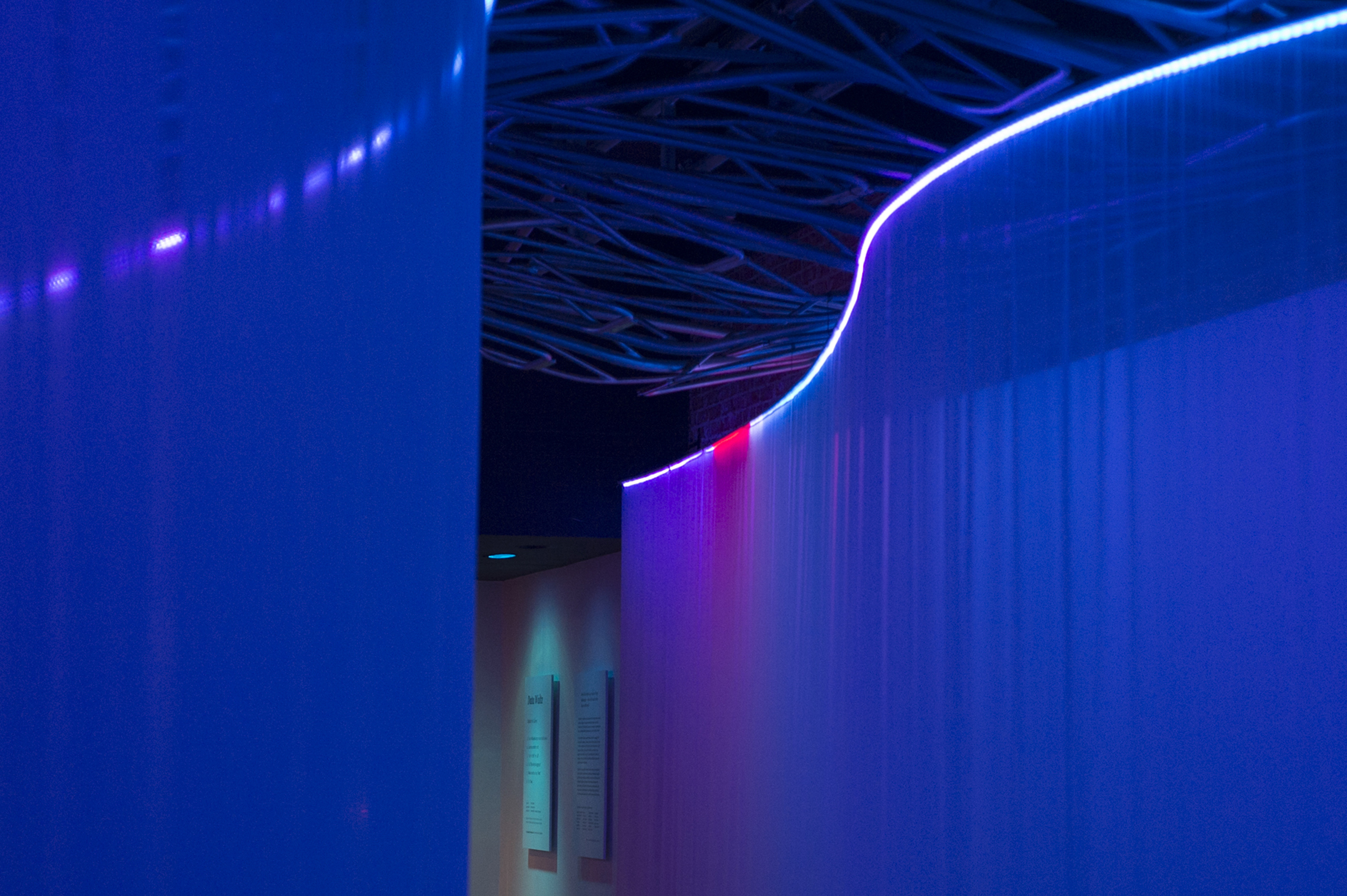 Purple lights down a curved hallway