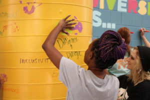 student placing hand print on the wall