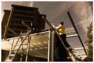 Student on ladder during construction of UT Zero