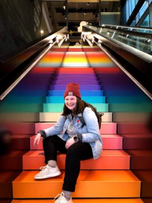 Student Maggie Redding on colorful stairs