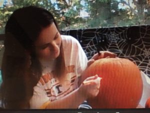 screenshot of student carving pumpkin