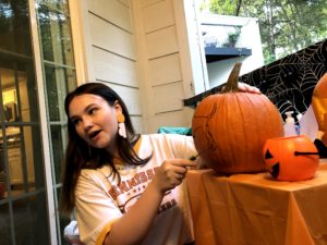 student carving a pumpkin
