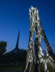 lighted tower at night next to church spire