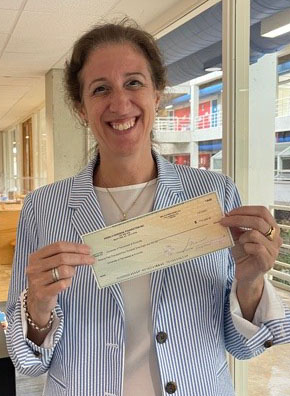 Milagros Zingoni holding a check