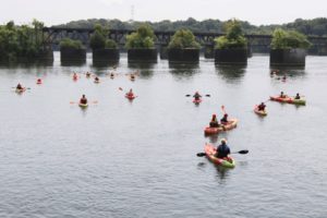 aerial shot of kayaks on water and a bridge