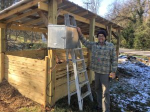 a wooden composting station and a man