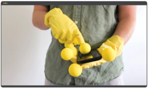 hands in yellow gloves holding a cell phone