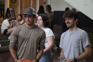 students smiling and playing cornhole