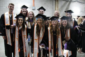 image of students smiling together in their graduation regalia