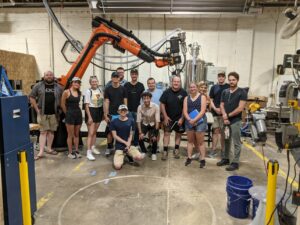 group of people with large robot arm