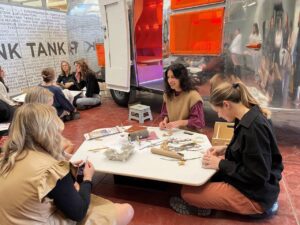 people sitting at tables outside of renovated Airstream trailer