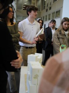 student talking with a model in front of him on the table