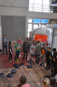 young students play a game near Airstream