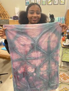 student holding their design on fabric