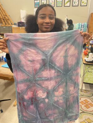 student holding their design on fabric