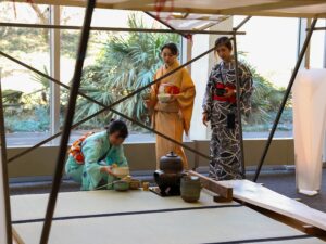 Three Asian women prepare the traditional Japanese tea ceremony.