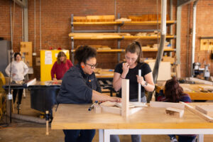Felicia Francine Dean, Assistant Professor in the School of Interior Architecture, works with students on their project at the Fab Lab.