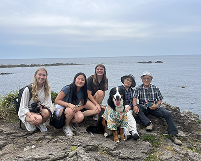 Michelle Chen, second from the left, with classmates and a Japanese couple and their Bernese Mountain dog at the beach.