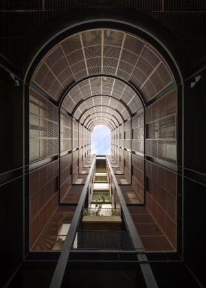 An upward view from the interior courtyard of the Volga Hotel, showcasing the building’s towering, symmetrical structure with a series of balconies. Photo by Rafael Gamo.