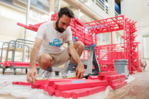 Dustin Del Moro, a third-year graduate student in landscape architecture, measures wood to build a sustainable deer blind inside the Art and Architecture building on September 20, 2024. When complete, the deer blind will be installed in a Wisconsin corn field October 5–14, 2024 as part of the Farm/Art DTour exhibition with the Wormfarm Institute. Photo by Steven Bridges/University of Tennessee.