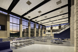 Spacious cafeteria at Lakeway Christian Academy with floor-to-ceiling windows, contemporary lighting fixtures, and rows of blue and gray seating beneath a high ceiling.